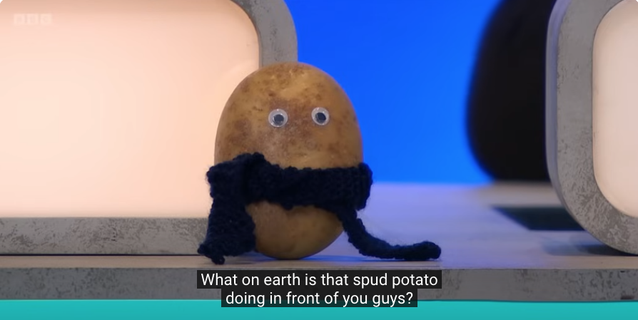 A potato with googly eyes wearing a scarf